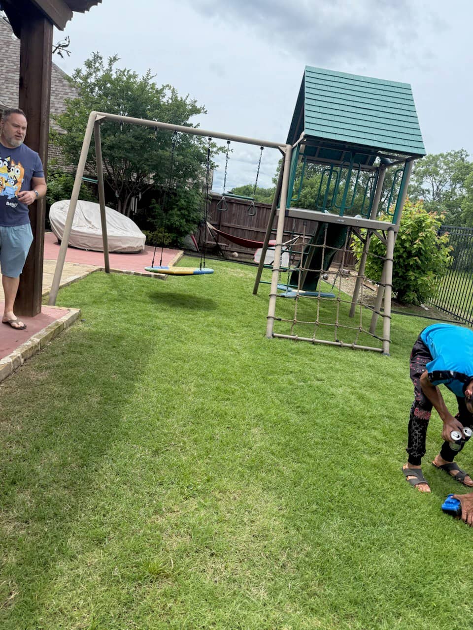 Backyard swing set with multiple swings and glider installed on level ground